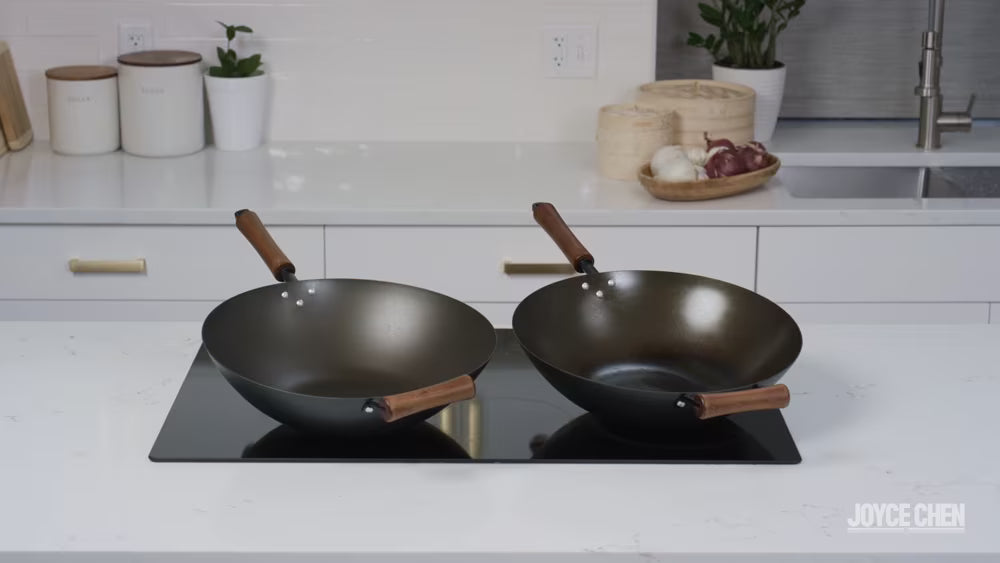 Load video: Joyce Chen wok seasoning guide: chef in blue apron seasons two pre-seasoned carbon steel woks on a black gas stove, with on-screen steps and a reminder to wash without soap.